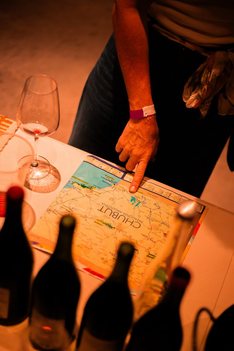 Botellas de vino sobre un mapa de Chubut en la feria